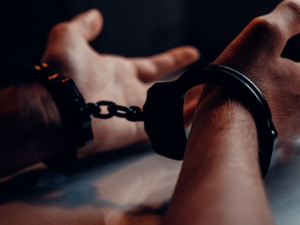 A mans hands in handcuffs with palms open towards to ceiling.