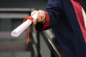 A close up of a diploma being held out.
