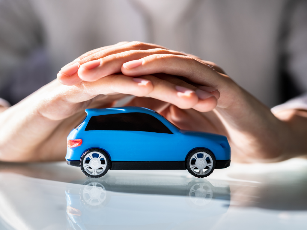 two hands holding a floating blue toy car.